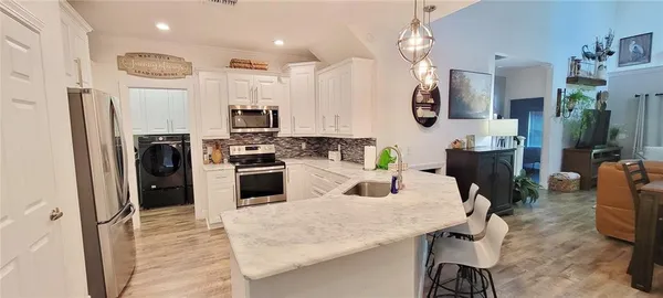 a kitchen with stainless steel appliances kitchen island granite countertop a refrigerator and microwave