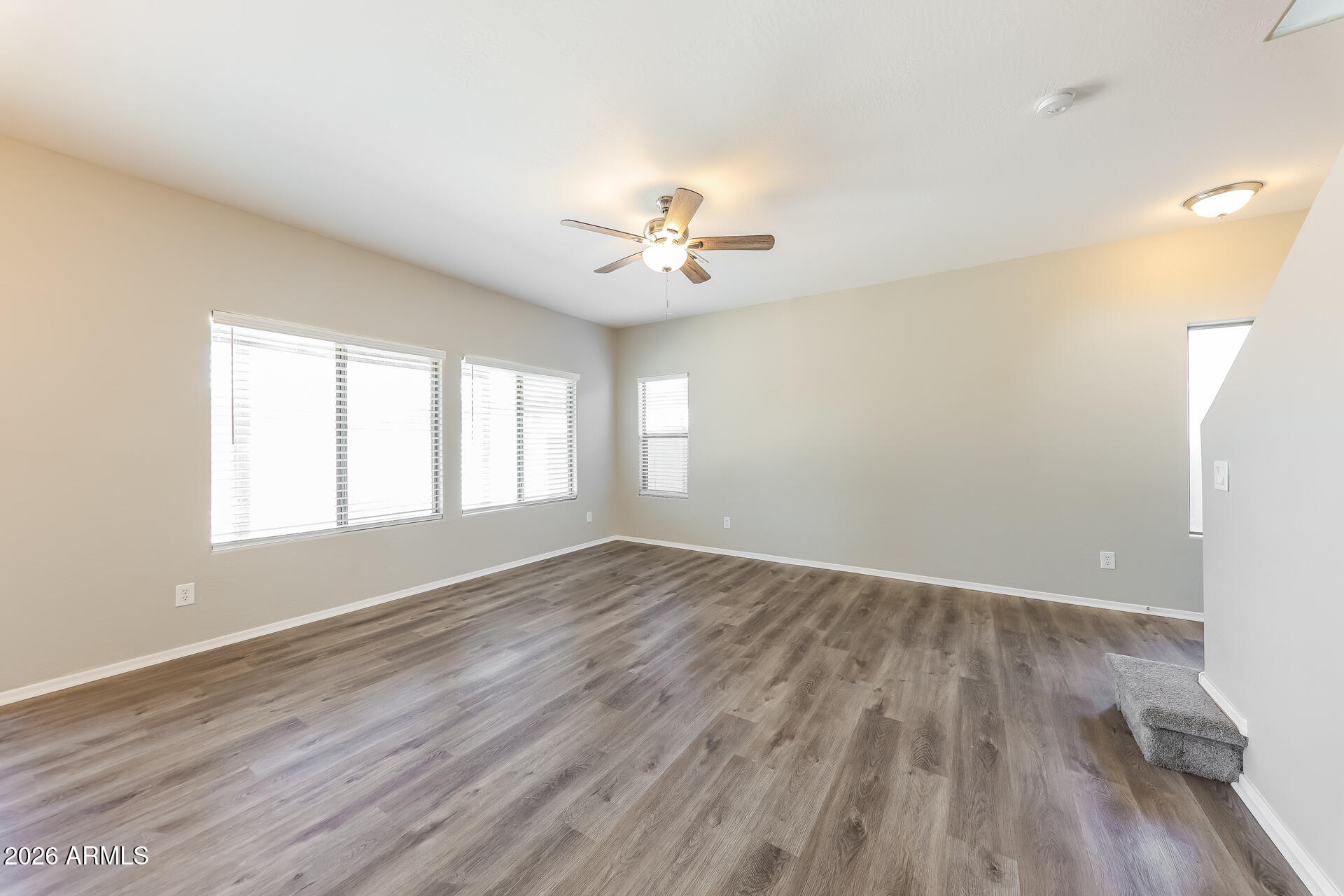 6716 South 36th Lane Phoenix, AZ 85041 - Photo 5 of 22 an empty room with wooden floor and windows