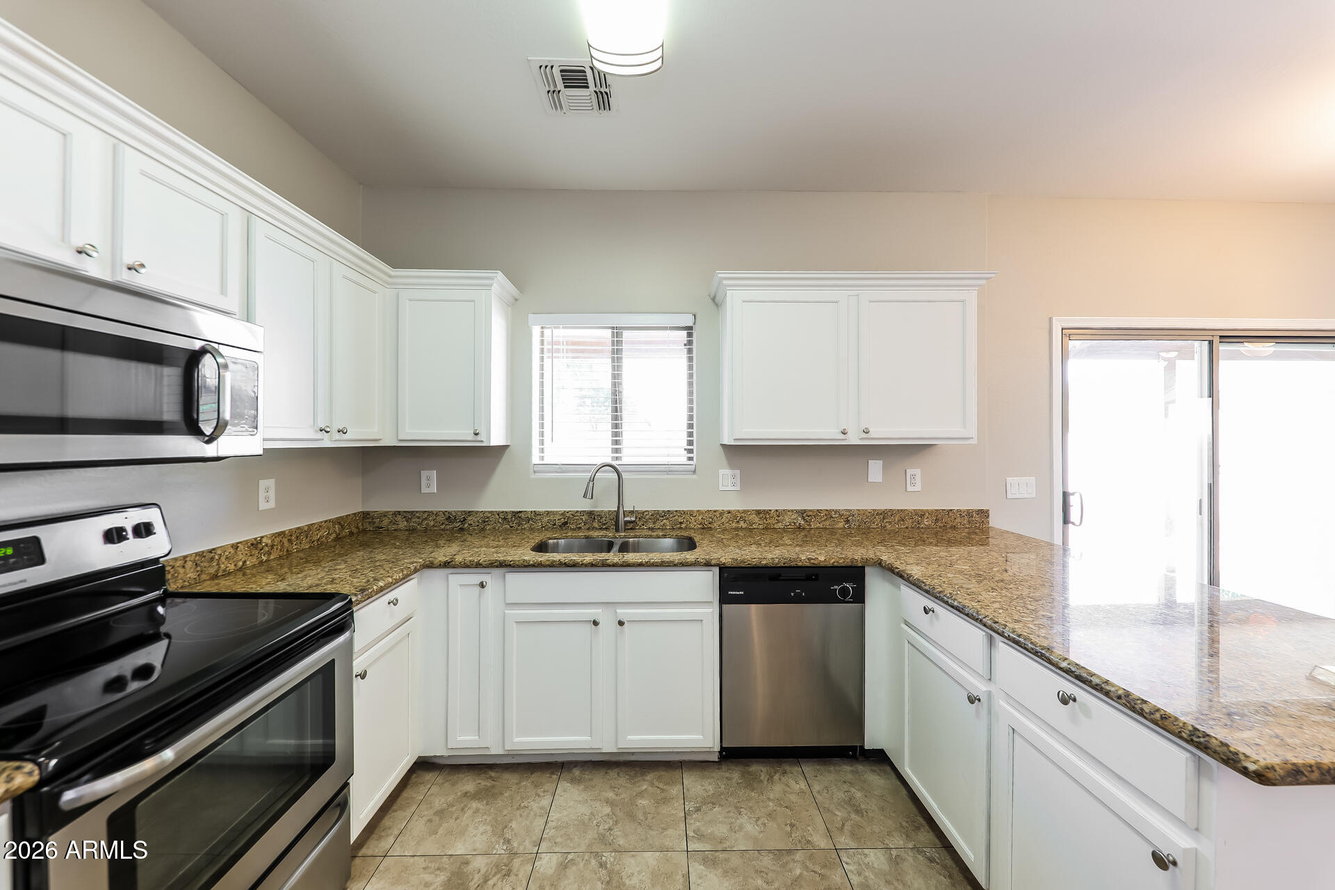 6716 South 36th Lane Phoenix, AZ 85041 - Photo 7 of 22 a kitchen with a sink stove top oven and cabinets