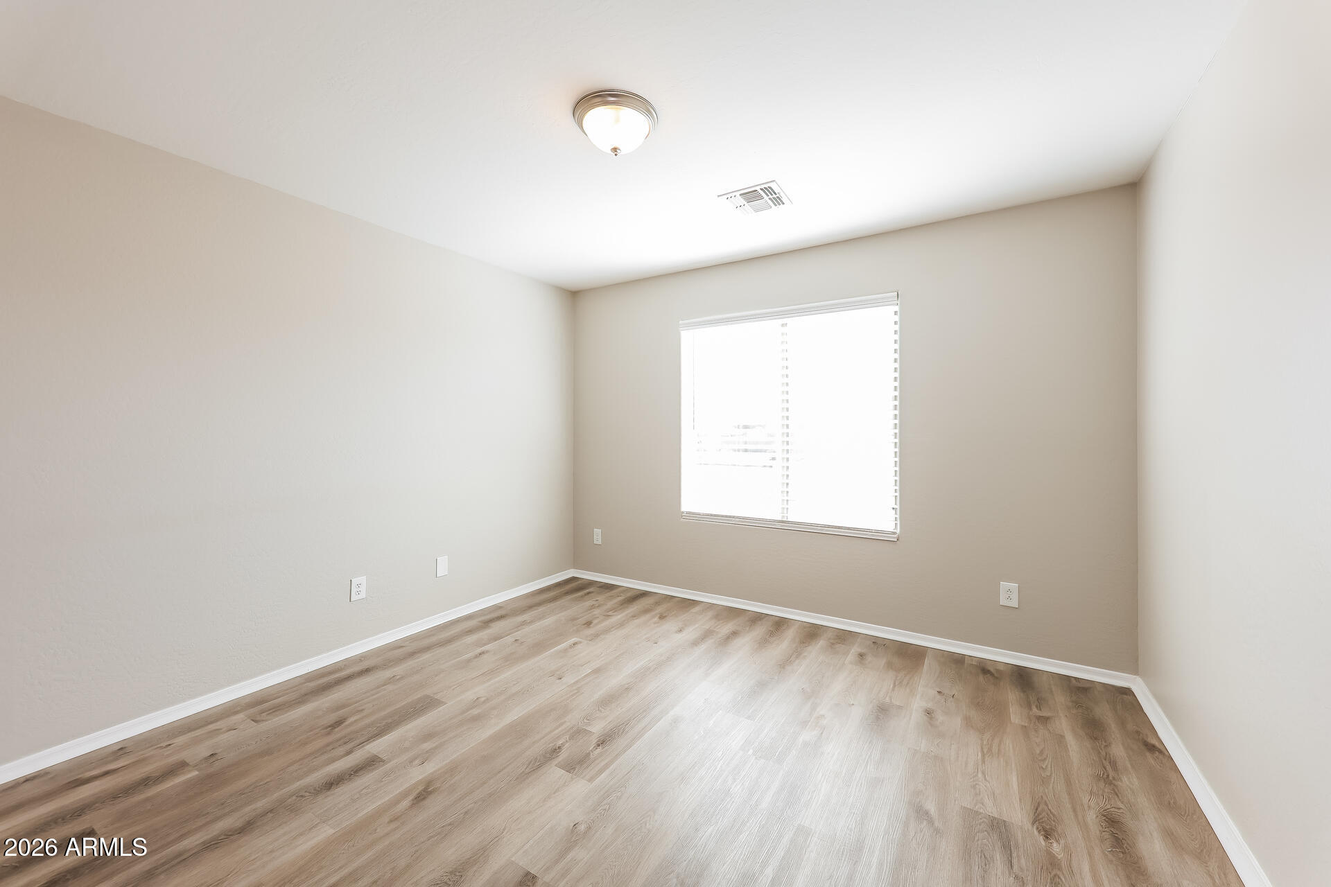 6716 South 36th Lane Phoenix, AZ 85041 - Photo 8 of 22 an empty room with wooden floor and windows
