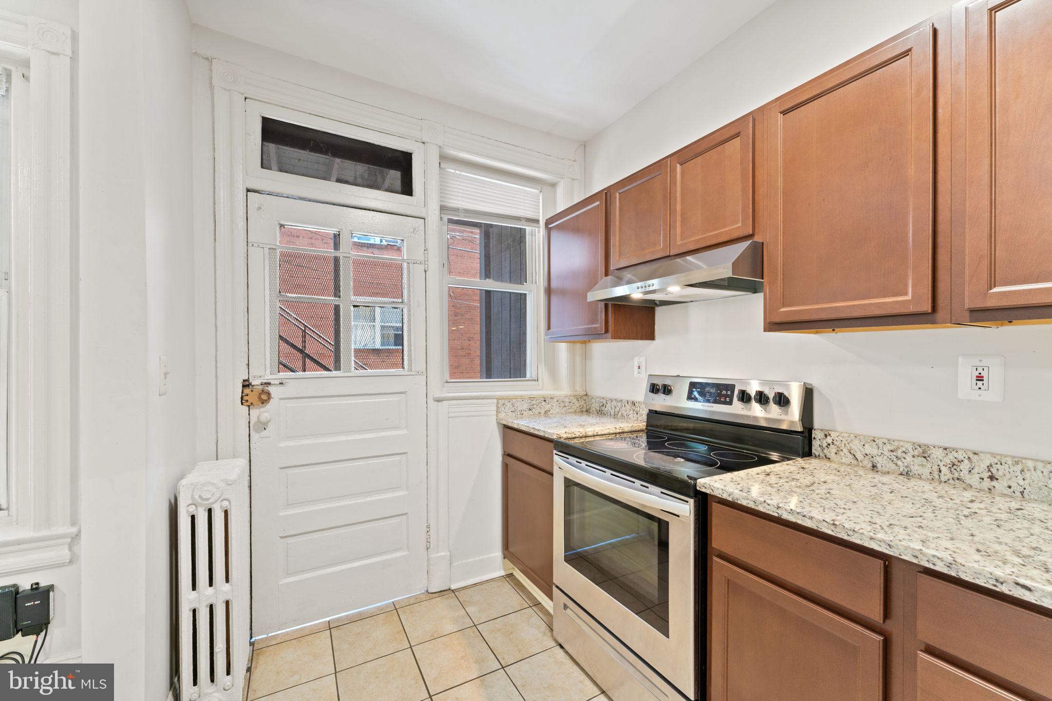 2707 11th Street Northwest Washington, DC 20001 - Photo 14 of 49 a kitchen with granite countertop white cabinets and white appliances