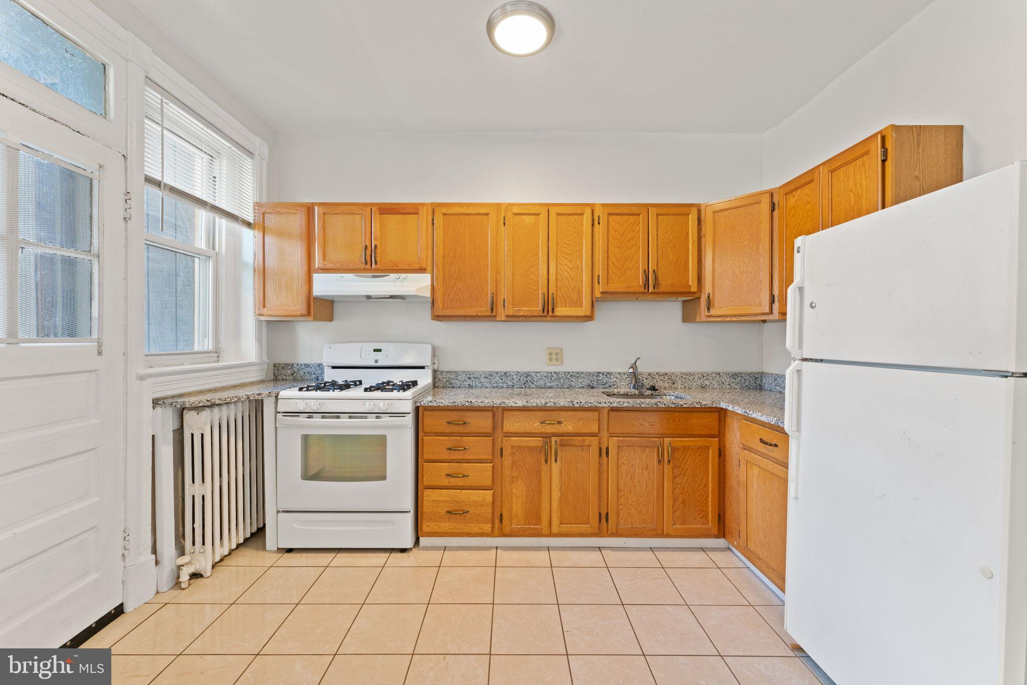 2707 11th Street Northwest Washington, DC 20001 - Photo 37 of 49 a kitchen with a refrigerator sink stove and cabinets