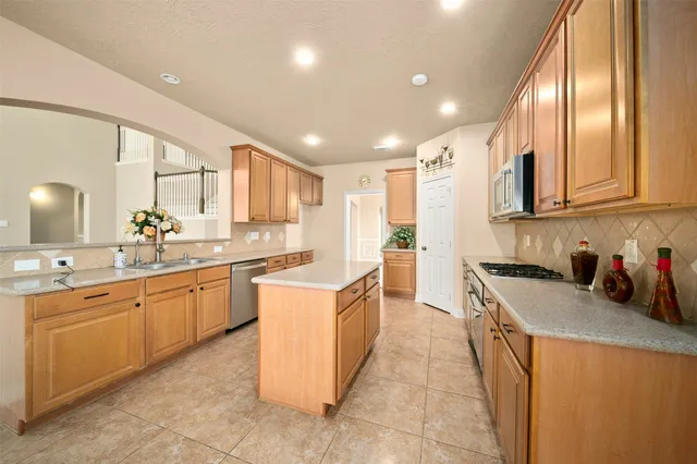 a kitchen with stainless steel appliances granite countertop a sink counter space cabinets and a large window