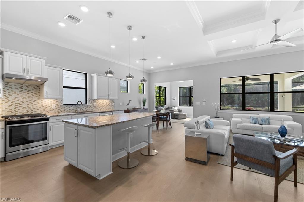 9410 Whooping Crane Way Naples, FL 34120 - Photo 12 of 38 a living room with stainless steel appliances granite countertop furniture and a kitchen