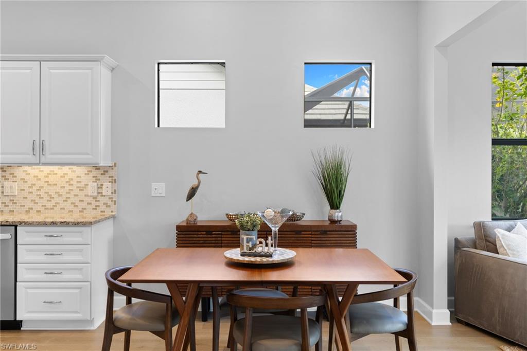 9410 Whooping Crane Way Naples, FL 34120 - Photo 14 of 38 a view of a dining room with furniture and wooden floor