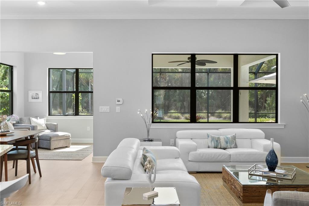 9410 Whooping Crane Way Naples, FL 34120 - Photo 16 of 38 a living room with furniture and floor to ceiling windows