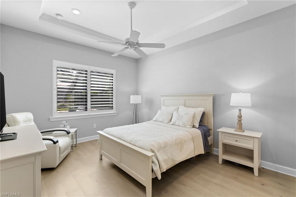 9410 Whooping Crane Way Naples, FL 34120 - Photo 17 of 38 a bedroom with a bed and a chandelier