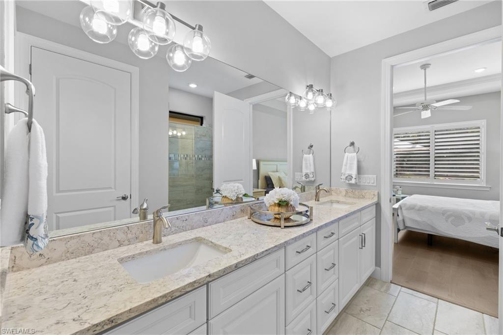 9410 Whooping Crane Way Naples, FL 34120 - Photo 19 of 38 a bathroom with a double vanity sink and a mirror