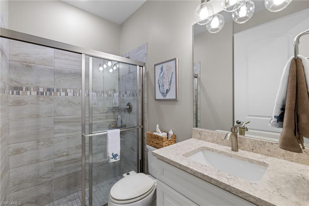 9410 Whooping Crane Way Naples, FL 34120 - Photo 23 of 38 a bathroom with a granite countertop sink toilet and shower
