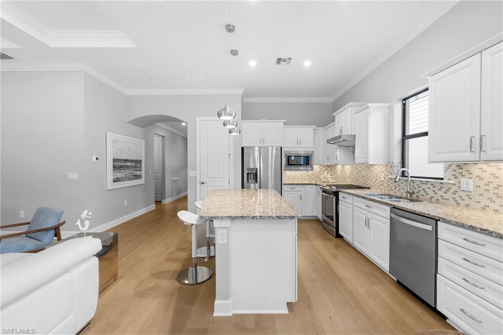 9410 Whooping Crane Way Naples, FL 34120 - Photo 5 of 38 a large kitchen with granite countertop a large counter top space a sink stainless steel appliances and cabinets