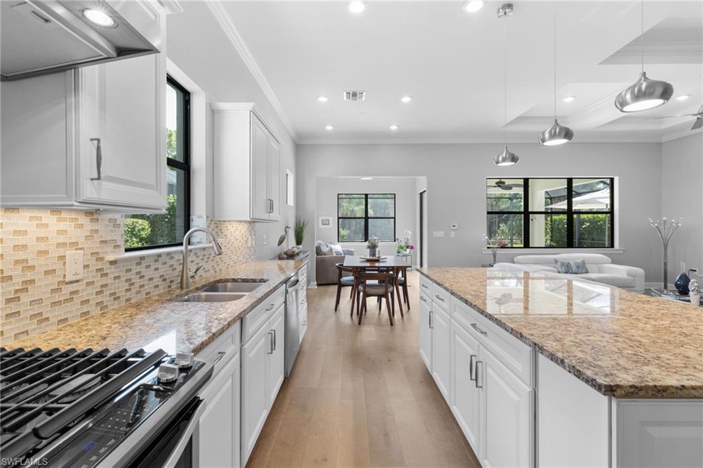 9410 Whooping Crane Way Naples, FL 34120 - Photo 9 of 38 a kitchen with counter top space a sink and appliances