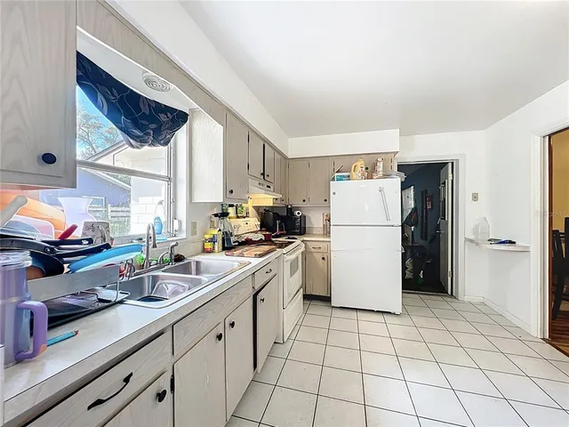 a kitchen with a sink a refrigerator and cabinets