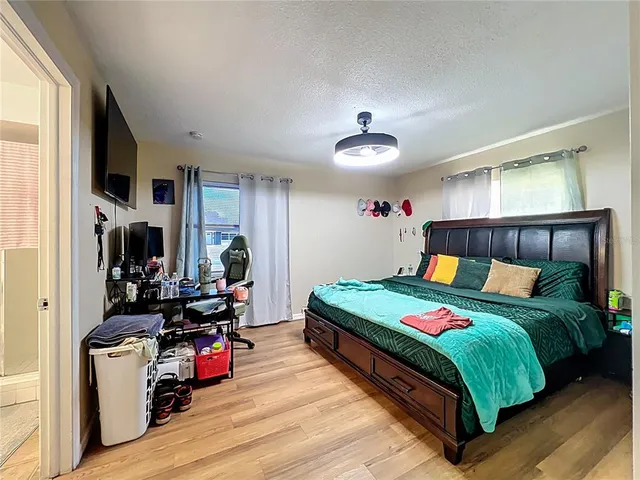 a bedroom with a bed and wooden floor