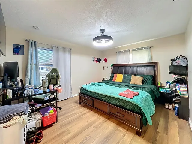 a bedroom with a bed and wooden floor