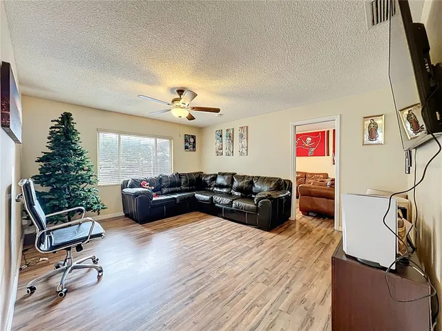 a living room with furniture flat screen tv and a large window