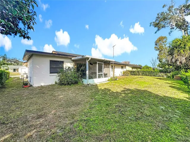 a view of a house with a backyard and a tree