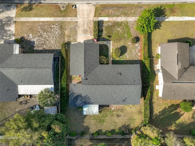 an aerial view of a residential houses with yard