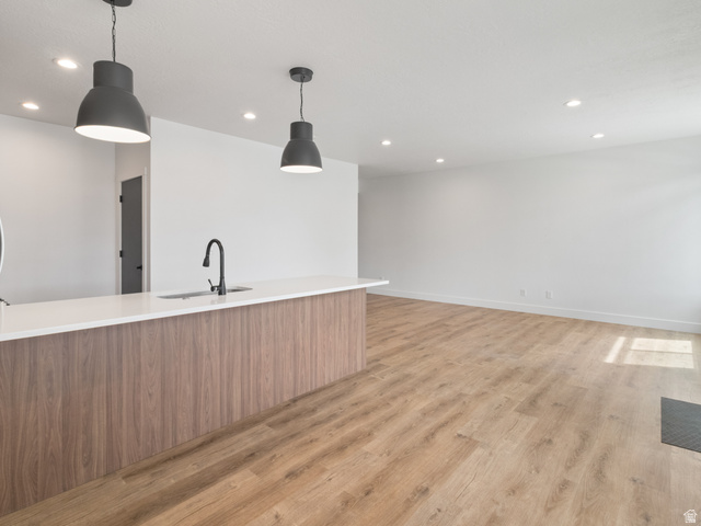 130 East 7085th South, Unit 3 Midvale, UT 84047 - Photo 6 of 30 Kitchen with modern cabinets, light wood-style flooring, pendant lighting, light stone countertops, and wood finish cabinetry
