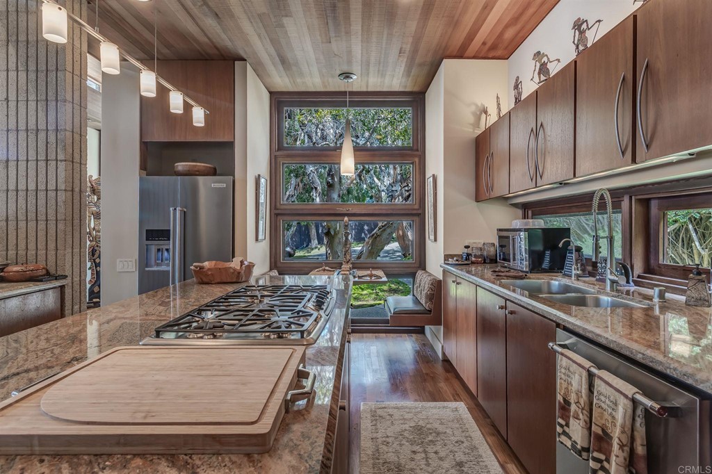 2054 Sheridan Road Encinitas, CA 92024 - Photo 19 of 58 a kitchen with stainless steel appliances granite countertop a stove a sink dishwasher and cabinets with wooden floor
