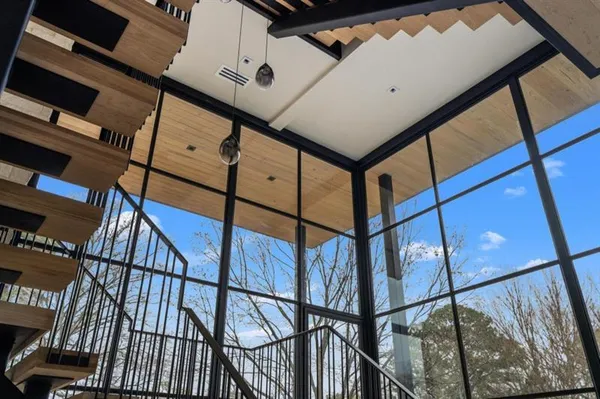 a view of staircase with lots of frames on wall and a window