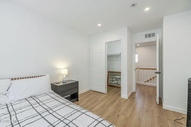 a spacious bedroom with a bed and a chandelier