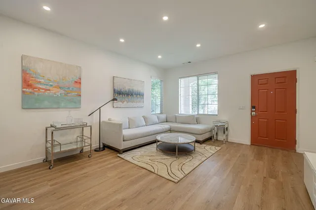 a living room with furniture and a wooden floor