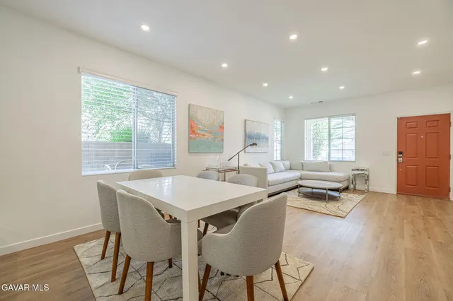 a large kitchen with a table chairs refrigerator and microwave