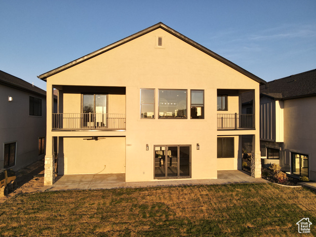 641 North Heritage Street, Unit 8 Mapleton, UT 84664 - Photo 4 of 34 Rear view of house featuring a balcony, a lawn, and stucco siding