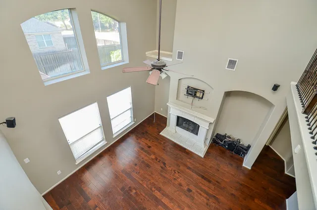 an empty room with windows and fan
