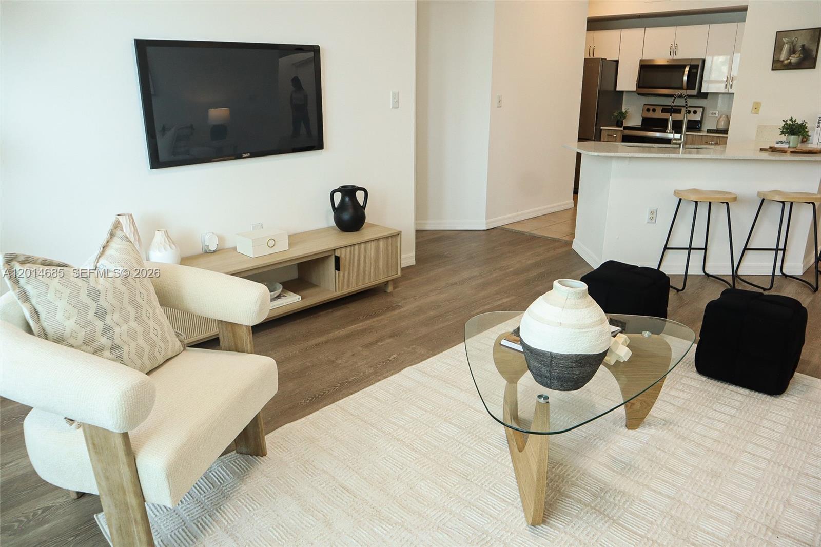 9172 Collins Avenue, Unit 212 Surfside, FL 33154 - Photo 3 of 23 a living room with furniture and a flat screen tv