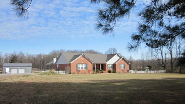 1017 Jump Off Road Bon Aqua, TN 37025 - Photo 1 of 18 a view of house with wooden fence and trees around