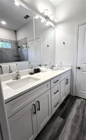 a bathroom with a double vanity sink a large mirror and vanity