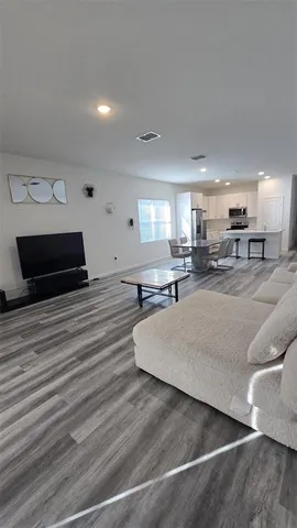 a living room with furniture and a wooden floor