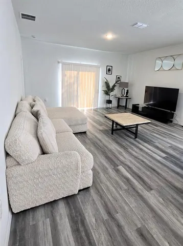 a living room with furniture and a wooden floor