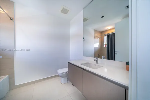 a white bath tub sitting next to a white sink and a shower