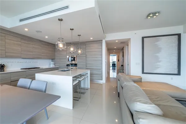 a large living room with stainless steel appliances kitchen island granite countertop furniture and a couch