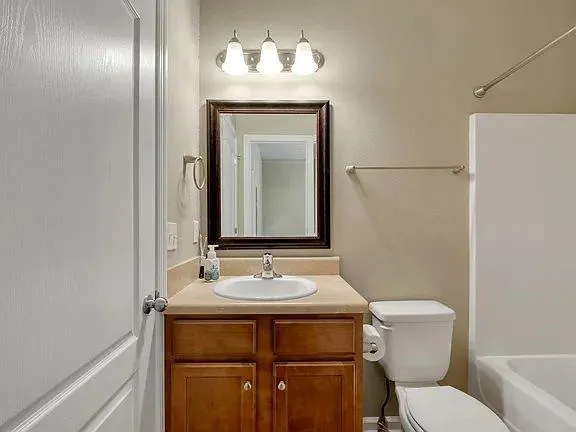 a bathroom with a toilet sink and mirror