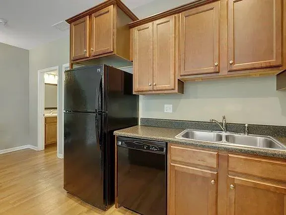 a kitchen with stainless steel appliances granite countertop a refrigerator a sink and cabinets