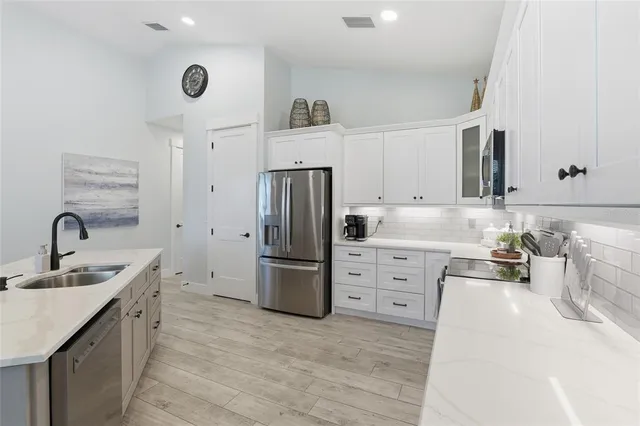 a kitchen with a sink a chair and wooden floor