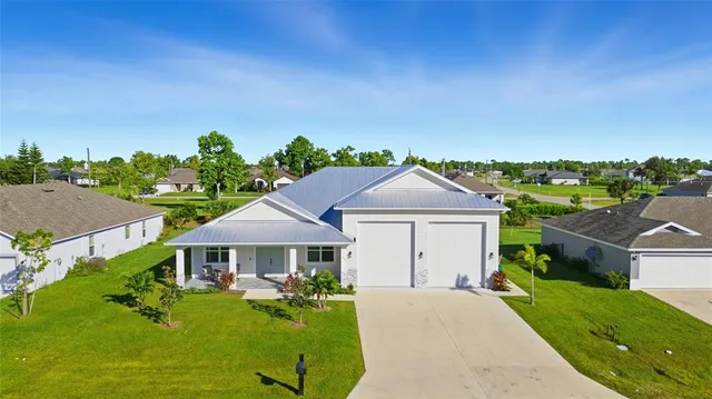 an aerial view of a city with lots of residential buildings ocean and mountain view in back