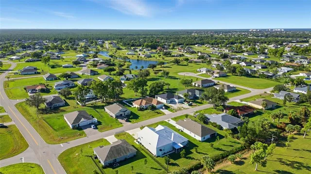 an aerial view of residential houses with outdoor space and swimming pool