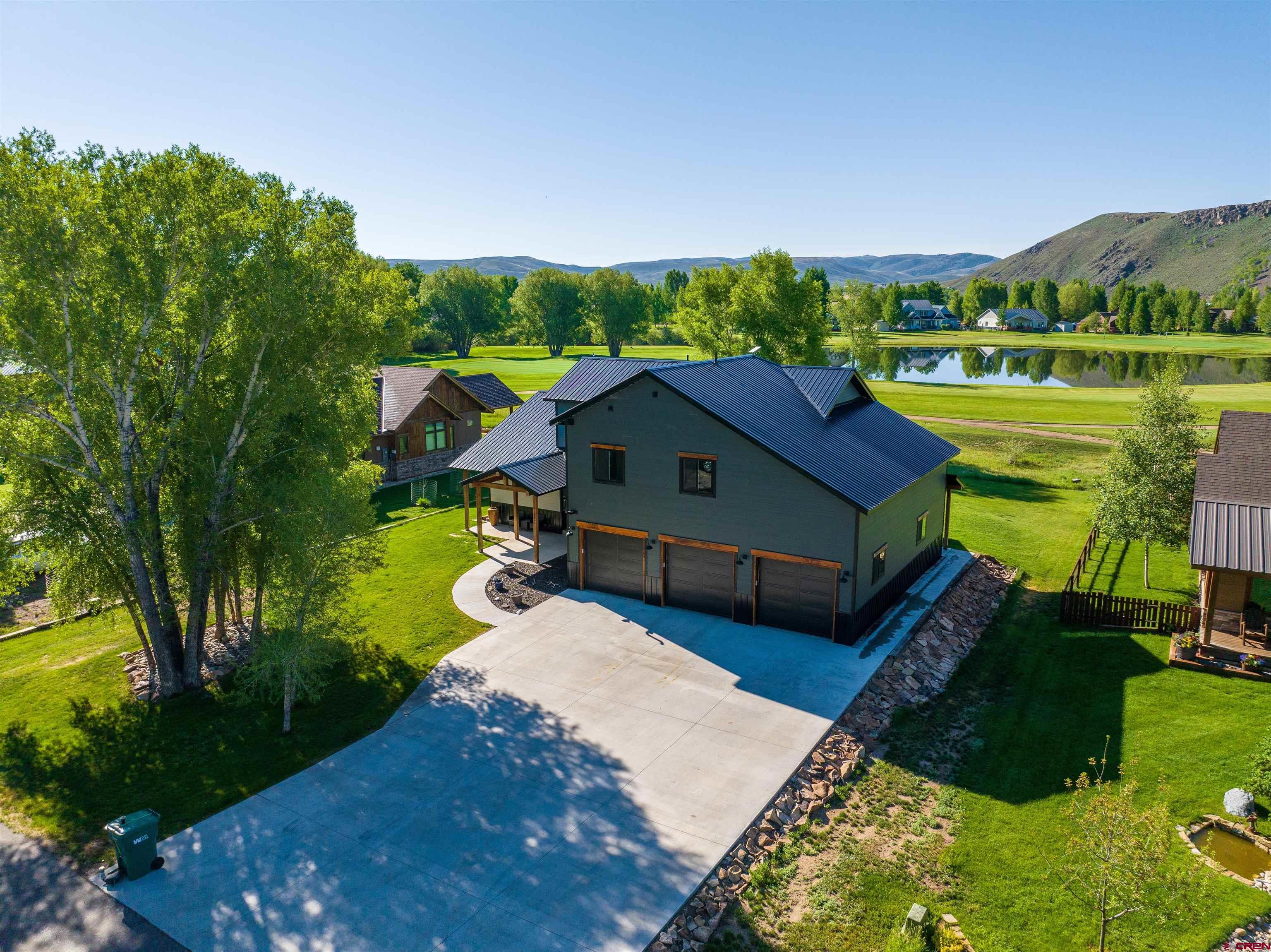 an aerial view of a house with garden space and a patio