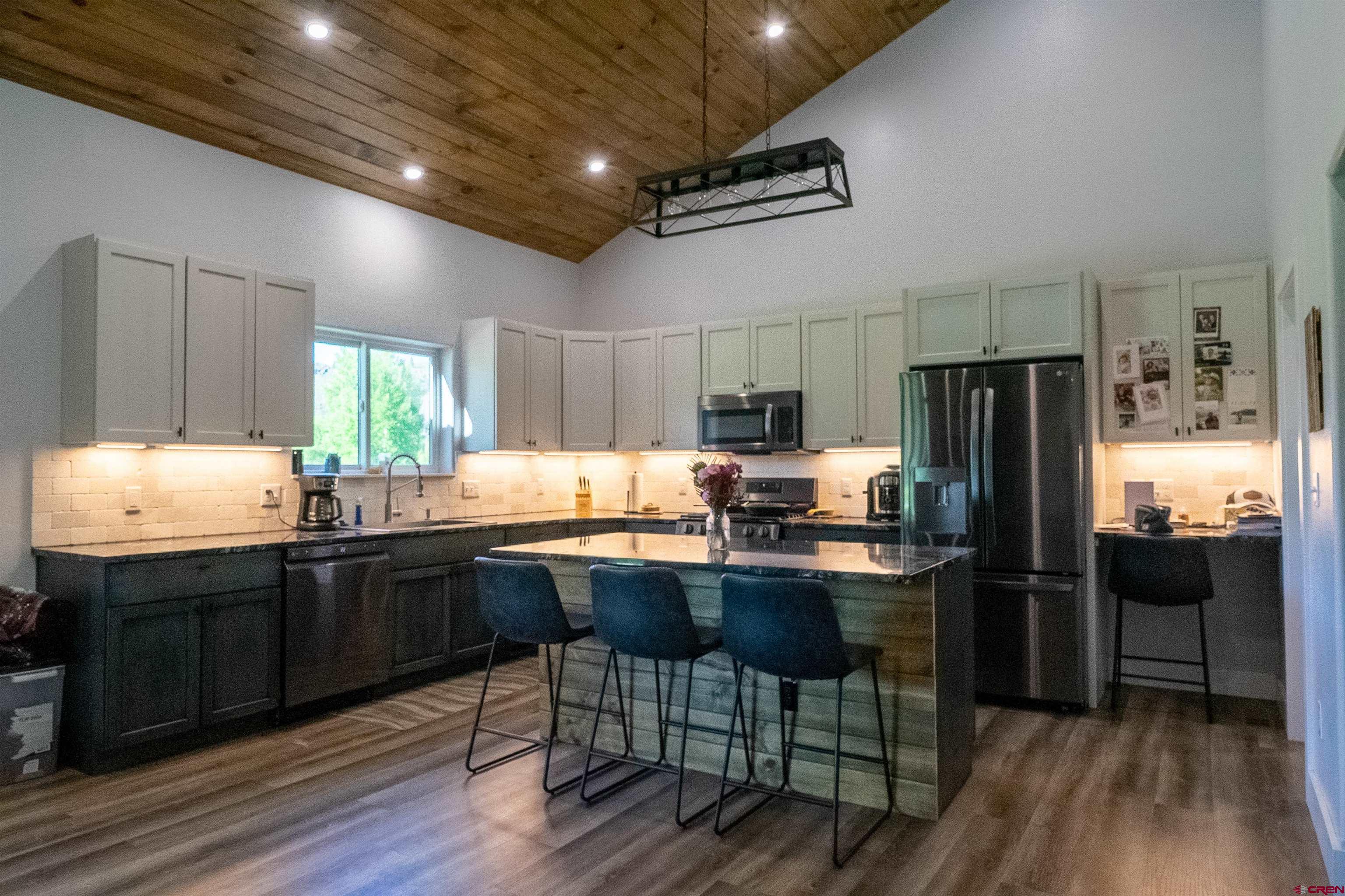 382 Tomichi Trail Gunnison, CO 81230 - Photo 14 of 34 a kitchen with granite countertop a refrigerator stove dining table and chairs