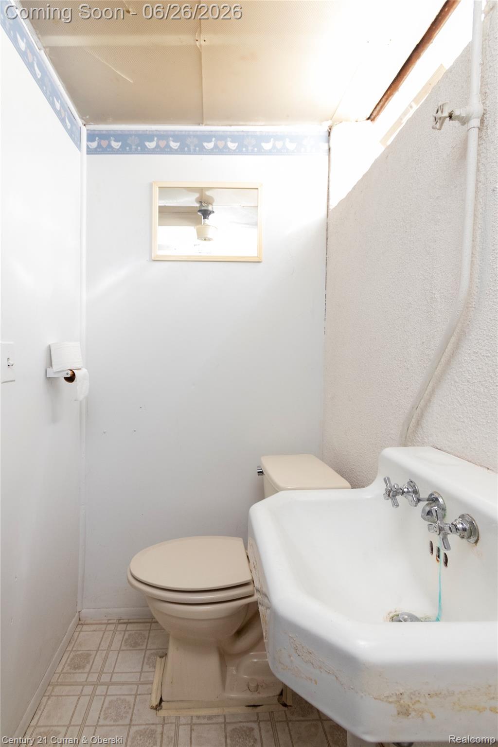 3220 Alice Street Dearborn, MI 48124 - Photo 31 of 39 Bathroom featuring a wall-mounted sink, a toilet, patterned vinyl flooring, and a mirrored medicine cabinet