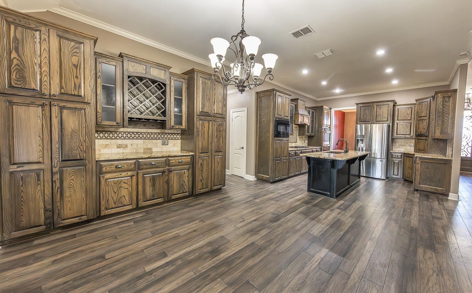 11302 Juneau Avenue Lubbock, TX 79424 - Photo 11 of 49 a open kitchen with stainless steel appliances granite countertop a stove a sink dishwasher and a refrigerator with wooden floor