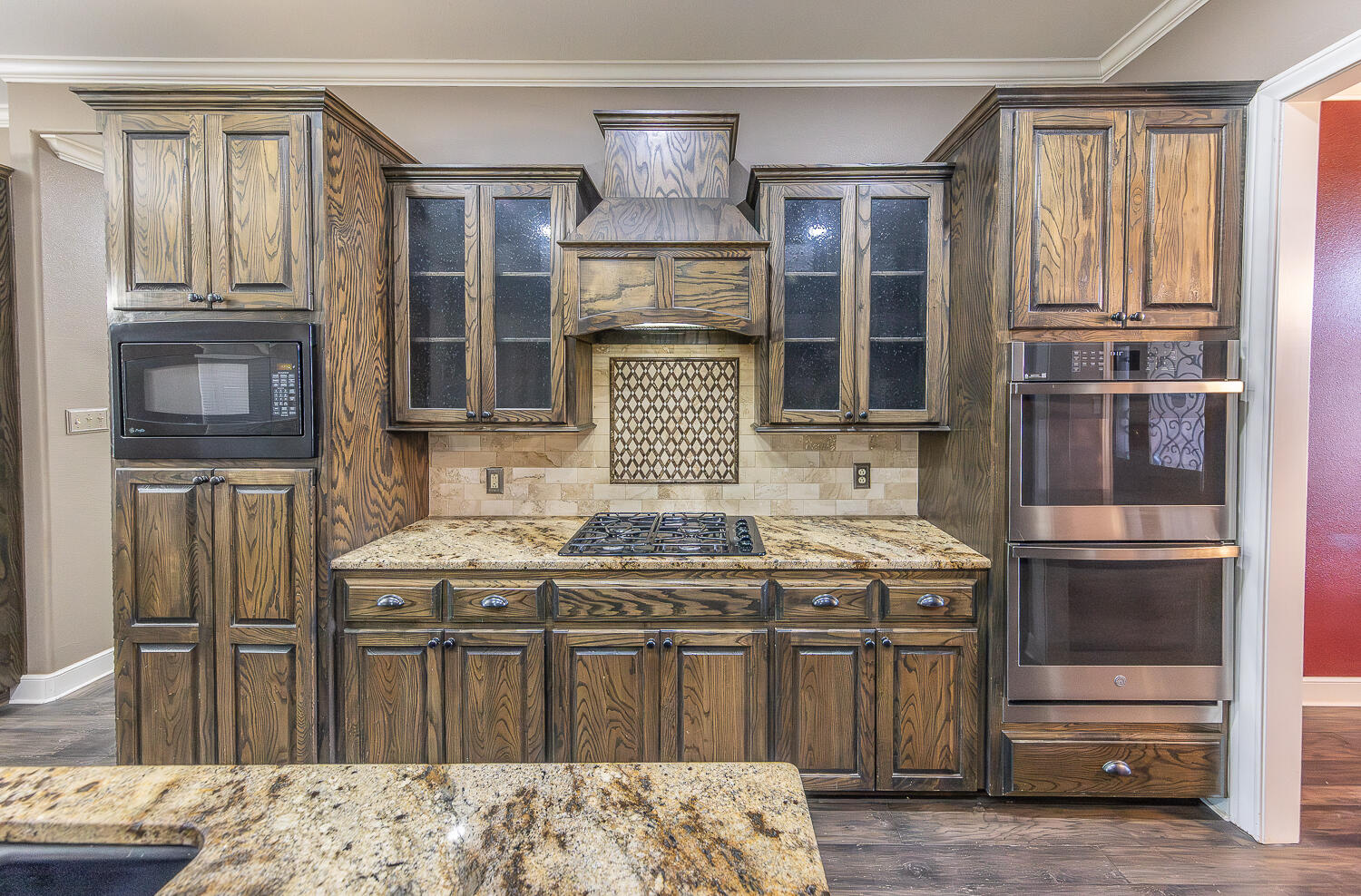 11302 Juneau Avenue Lubbock, TX 79424 - Photo 12 of 49 a kitchen with a stove and a wooden cabinets