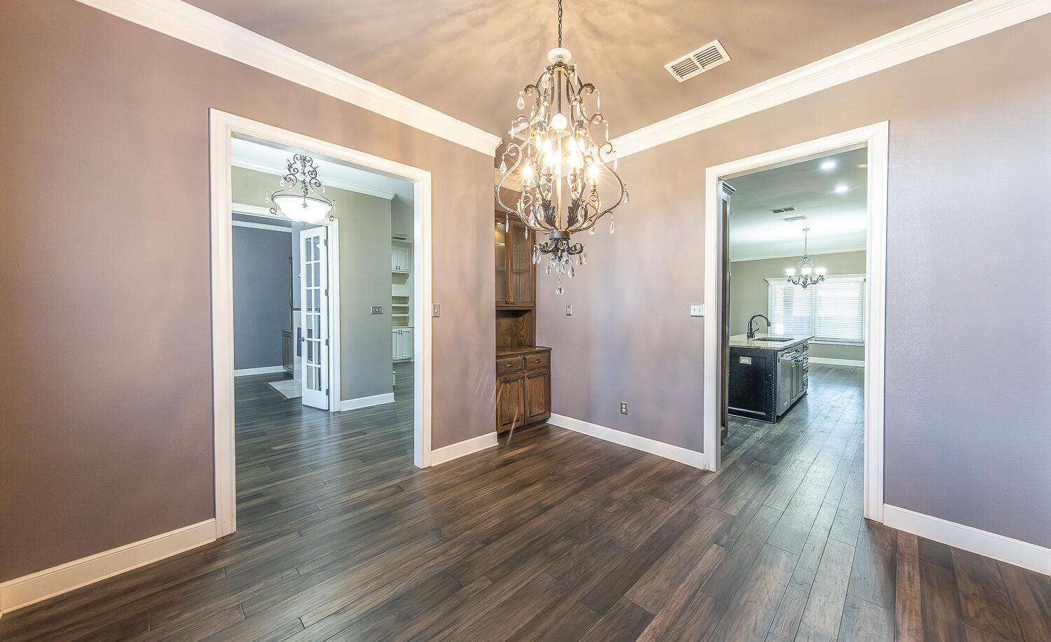 11302 Juneau Avenue Lubbock, TX 79424 - Photo 17 of 49 a view of a hallway with wooden floor and a chandelier