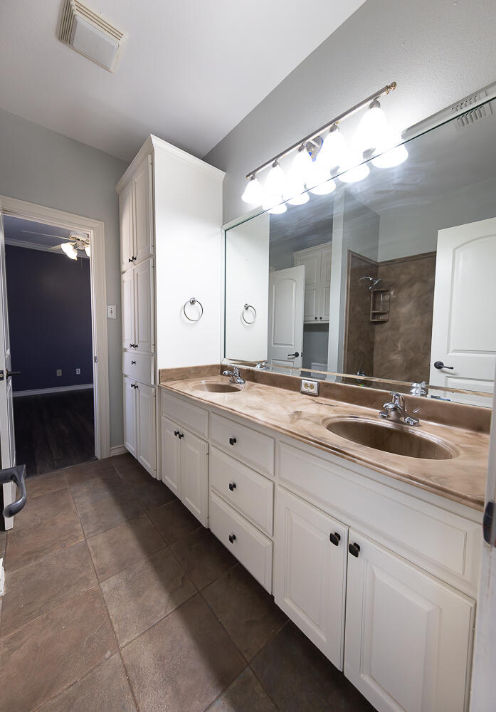 11302 Juneau Avenue Lubbock, TX 79424 - Photo 28 of 49 a spacious bathroom with a double vanity sink and a mirror