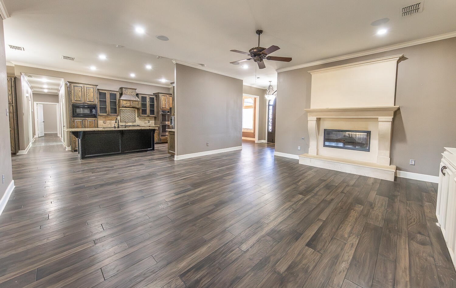 11302 Juneau Avenue Lubbock, TX 79424 - Photo 5 of 49 an empty room with wooden floor fireplace and windows