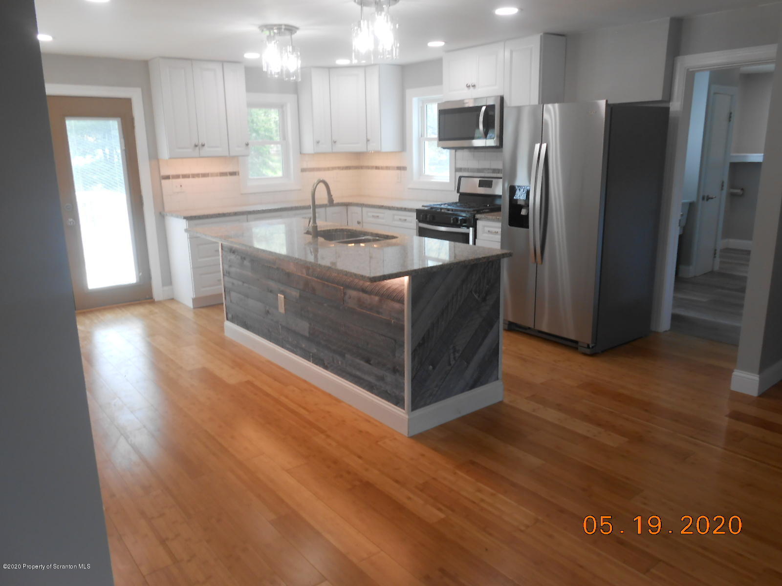 636 Bennett Road Meshoppen, PA 18630 - Photo 5 of 25 a kitchen with stainless steel appliances granite countertop a refrigerator a sink a stove a microwave and island with wooden floor